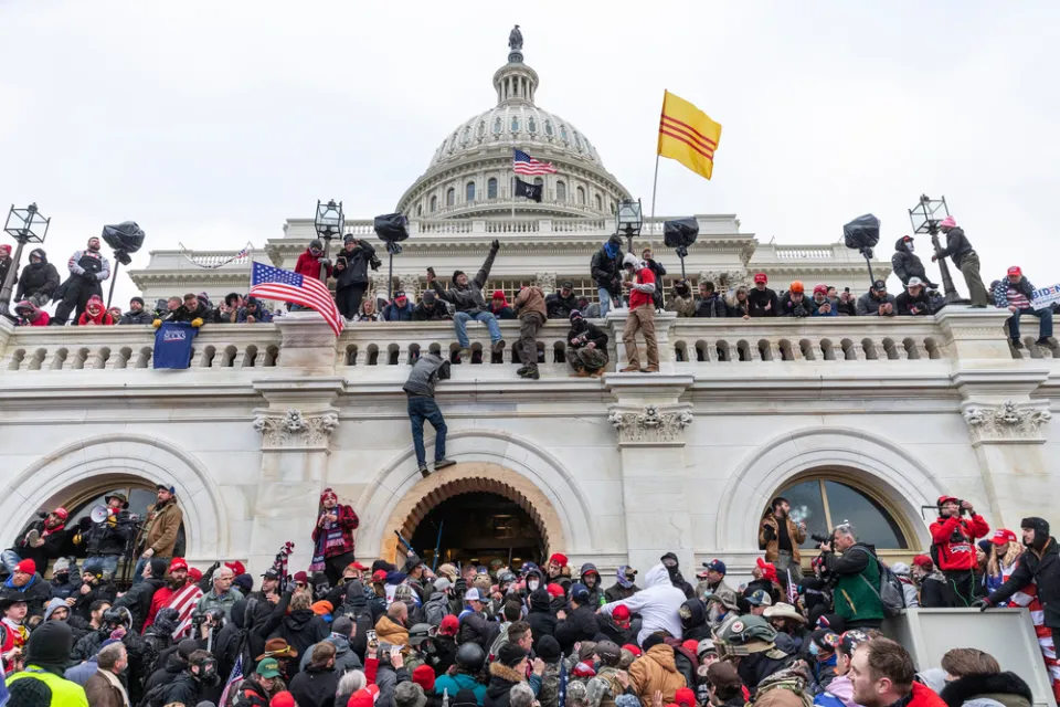Trump supporting insurrectionists scale the walls of the U.S. Capitol Building on January 6, 2021.
